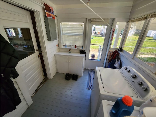 laundry area featuring electric panel, laundry area, wood-type flooring, and washer / dryer