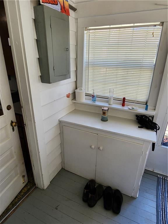 bathroom with electric panel, a wealth of natural light, and wood finished floors