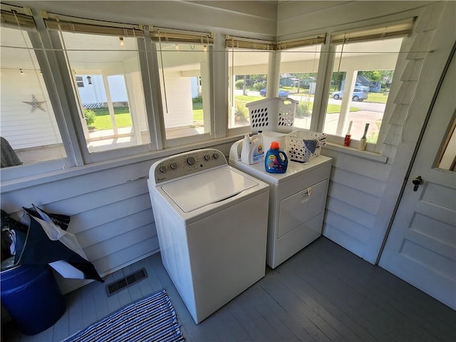 laundry room with washing machine and clothes dryer, laundry area, visible vents, and dark wood-type flooring