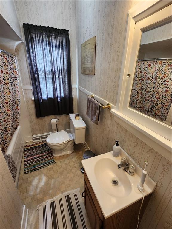 bathroom with vanity, toilet, a shower with shower curtain, and wallpapered walls