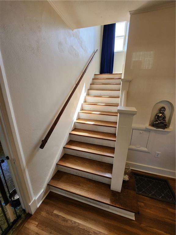 staircase with baseboards and wood finished floors