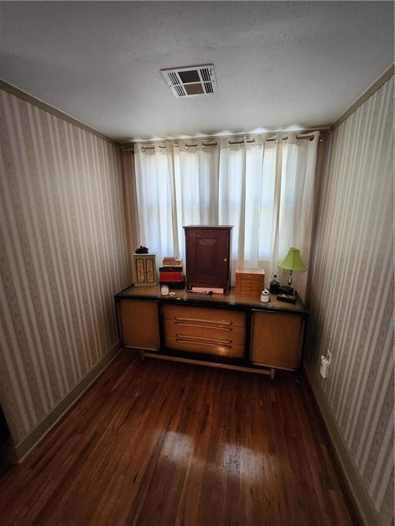 office with visible vents, dark wood finished floors, and wallpapered walls