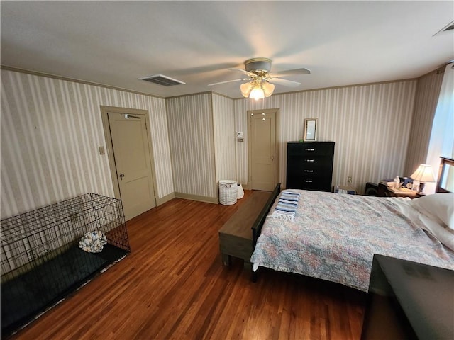 bedroom featuring a ceiling fan, wallpapered walls, and wood finished floors