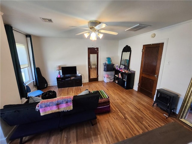 living room featuring baseboards, ceiling fan, visible vents, and wood finished floors