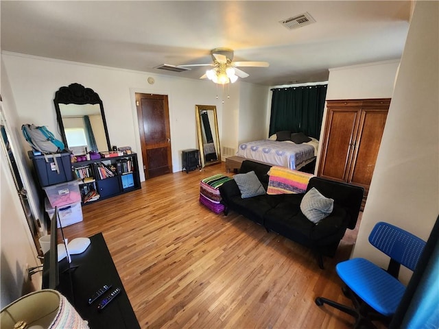 bedroom featuring crown molding, visible vents, and light wood-style flooring