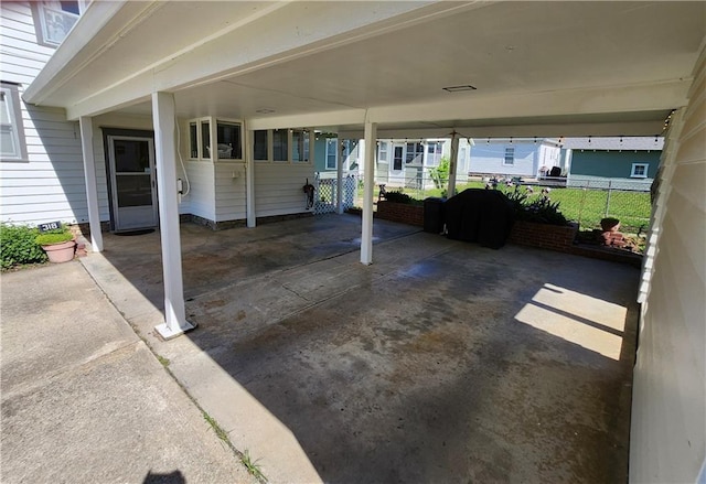 view of patio featuring fence and a carport