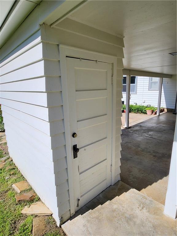 doorway to property featuring an attached carport
