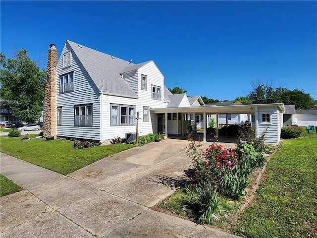 view of front of property featuring a chimney, a carport, a front lawn, driveway, and roof with shingles