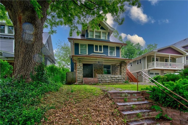 2803 Harrison St, Kansas City, MO 64109 - view of front facade featuring stairway, stone siding, and covered porch