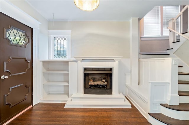 2803 Harrison St, Kansas City, MO 64109 - entrance foyer with stairs, wood finished floors, crown molding, healthy amount of natural light, and a fireplace with raised hearth