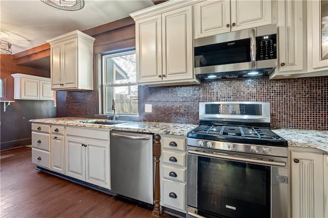2803 Harrison St, Kansas City, MO 64109 - kitchen with stainless steel appliances, dark wood-style floors, a sink, tasteful backsplash, and light stone counters