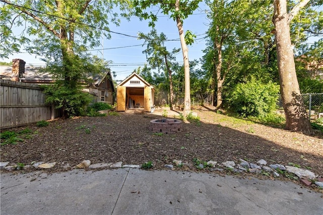 2803 Harrison St, Kansas City, MO 64109 - fenced backyard with a fire pit, a storage shed, and an outbuilding