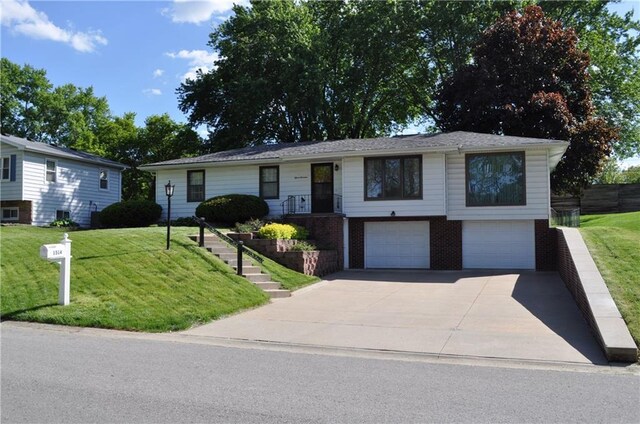 1514 Frankie Ln, Saint Joseph, MO 64503 - view of front facade with driveway, brick siding, a garage, and a front yard