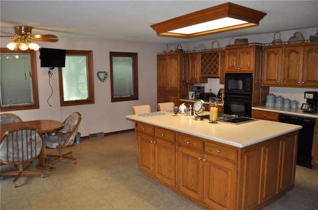 1514 Frankie Ln, Saint Joseph, MO 64503 - kitchen with brown cabinetry, visible vents, ceiling fan, black appliances, and light countertops