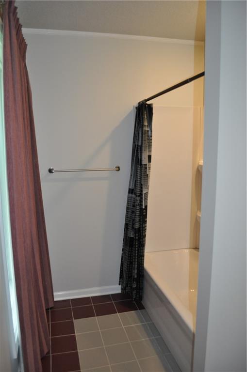 1514 Frankie Ln, Saint Joseph, MO 64503 - bathroom with baseboards, shower / bath combo with shower curtain, and tile patterned floors