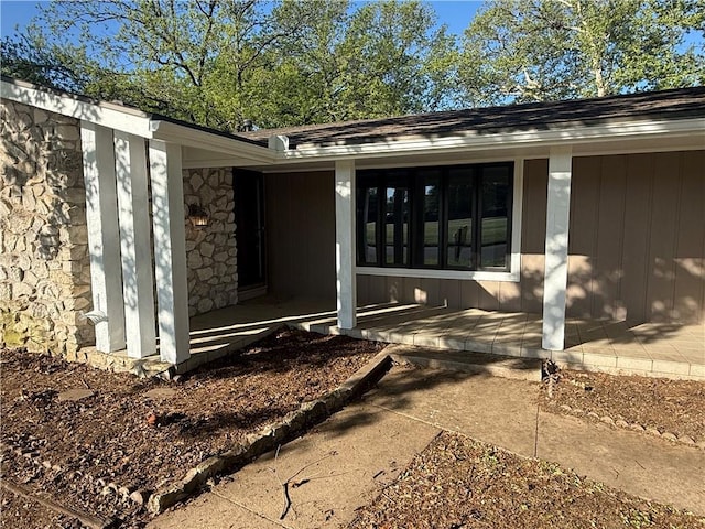 property entrance with covered porch and stone siding