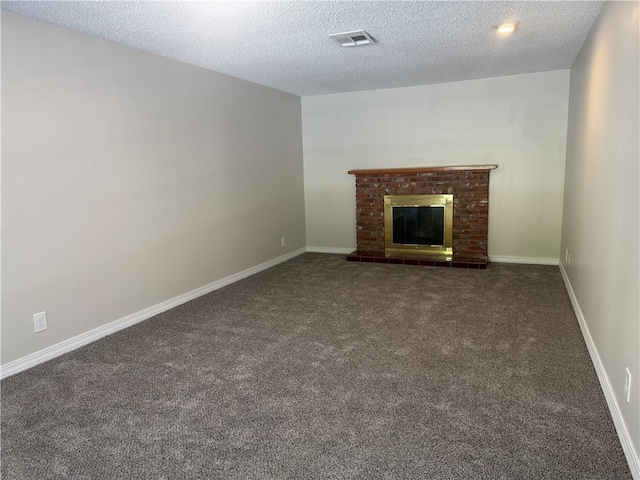 unfurnished living room with carpet, a textured ceiling, visible vents, and a fireplace