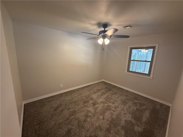 empty room with visible vents, baseboards, a ceiling fan, and dark colored carpet
