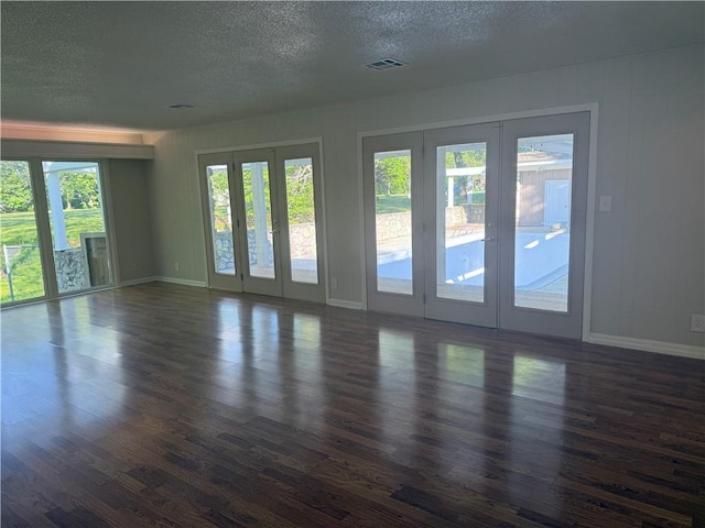 interior space featuring dark wood-style floors, a textured ceiling, french doors, and visible vents