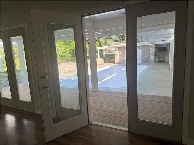 doorway to outside with a fireplace, a healthy amount of sunlight, and wood finished floors