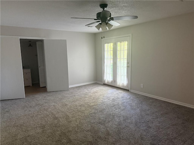 empty room with a textured ceiling, baseboards, ceiling fan, and carpet floors