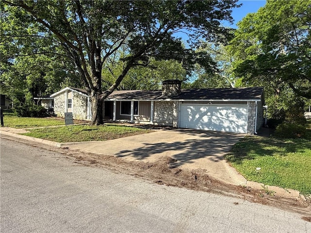 single story home with driveway, an attached garage, and a front yard