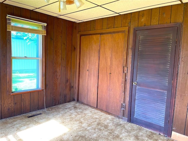 509 Whitcomb St, Lathrop, MO 64465 - unfurnished bedroom with carpet floors, wood walls, and a closet