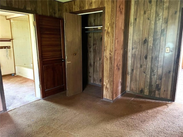 509 Whitcomb St, Lathrop, MO 64465 - unfurnished bedroom featuring wood walls, carpet flooring, and a closet