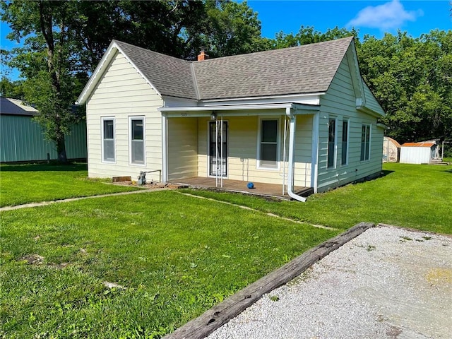 509 Whitcomb St, Lathrop, MO 64465 - bungalow-style home featuring roof with shingles, a front yard, a porch, a shed, and a chimney