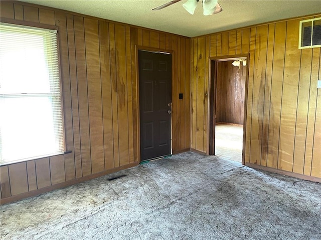 509 Whitcomb St, Lathrop, MO 64465 - unfurnished room featuring wood walls, ceiling fan, and carpet floors