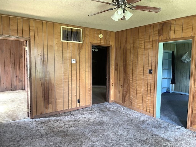 509 Whitcomb St, Lathrop, MO 64465 - carpeted spare room featuring wooden walls, ceiling fan, and a textured ceiling