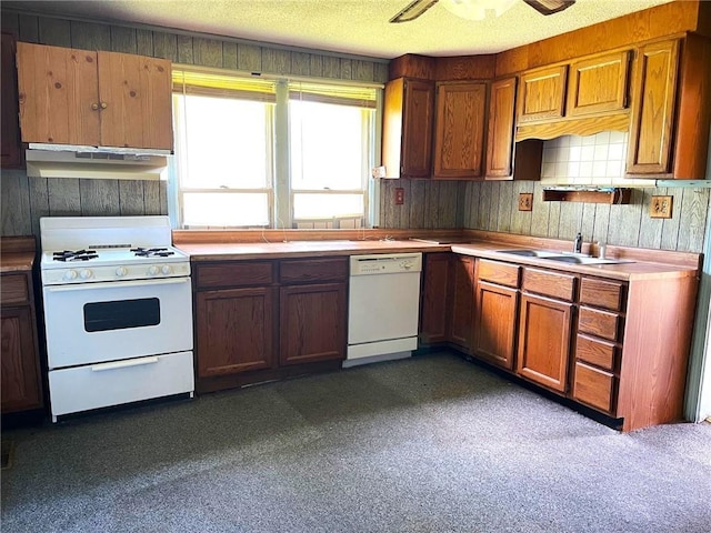 509 Whitcomb St, Lathrop, MO 64465 - kitchen featuring white appliances, under cabinet range hood, brown cabinets, and light countertops
