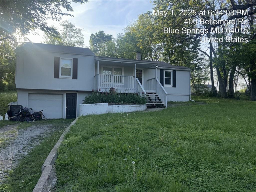 405 S Bellemere Rd, Blue Springs, MO 64015 - view of front facade with a porch, a front yard, a garage, and driveway