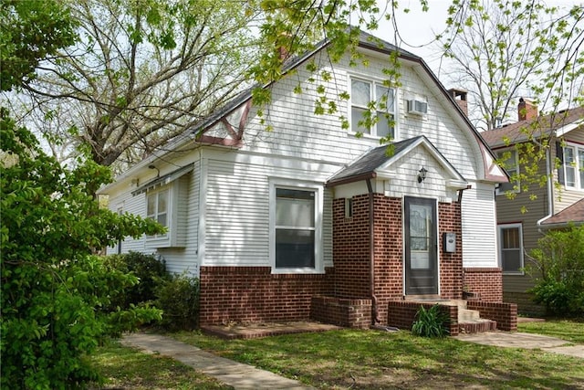 1221 Morgan Ave, Parsons, KS 67357 - view of front of home with a gambrel roof, a chimney, and brick siding