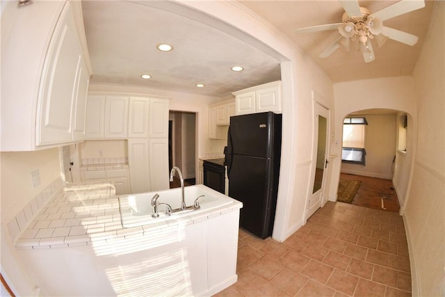 1221 Morgan Ave, Parsons, KS 67357 - kitchen featuring freestanding refrigerator, recessed lighting, a sink, a peninsula, and arched walkways
