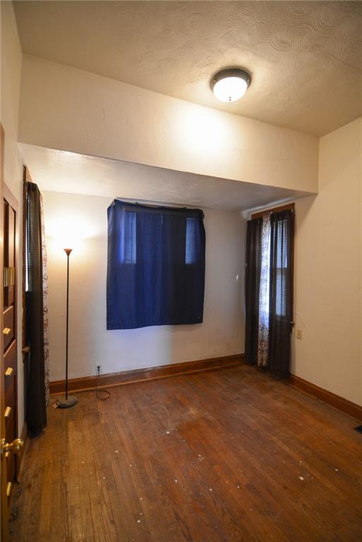 1221 Morgan Ave, Parsons, KS 67357 - empty room featuring baseboards and hardwood / wood-style flooring