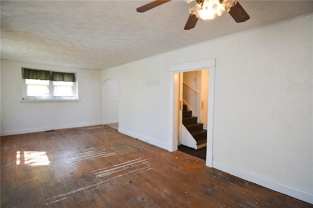 1221 Morgan Ave, Parsons, KS 67357 - unfurnished room featuring hardwood / wood-style flooring, baseboards, ceiling fan, and stairs