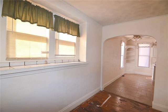 1221 Morgan Ave, Parsons, KS 67357 - hall featuring crown molding, brick floor, arched walkways, and baseboards