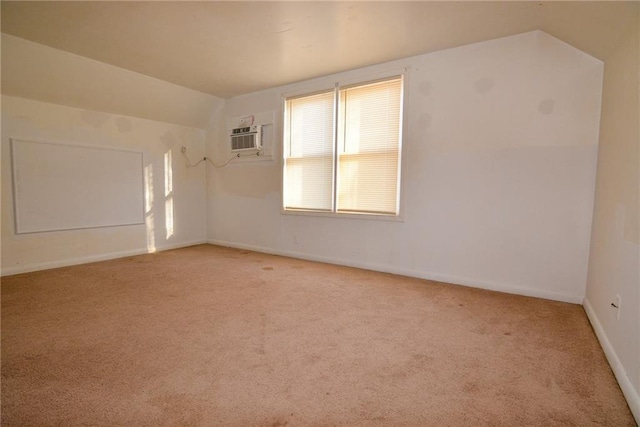 1221 Morgan Ave, Parsons, KS 67357 - spare room featuring light colored carpet, lofted ceiling, an AC wall unit, and baseboards