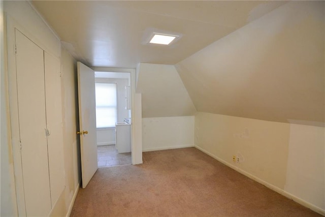 1221 Morgan Ave, Parsons, KS 67357 - additional living space with vaulted ceiling, light colored carpet, and baseboards