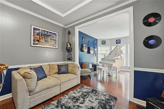 living room featuring wood finished floors, baseboards, and crown molding