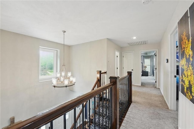 corridor with a chandelier, an upstairs landing, light carpet, baseboards, and recessed lighting