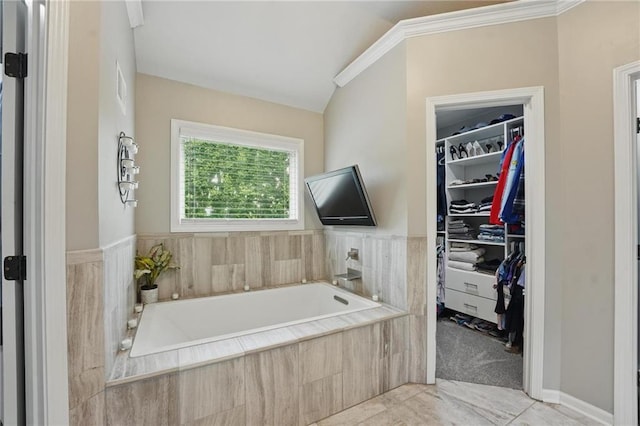 full bath featuring a spacious closet, a garden tub, and lofted ceiling