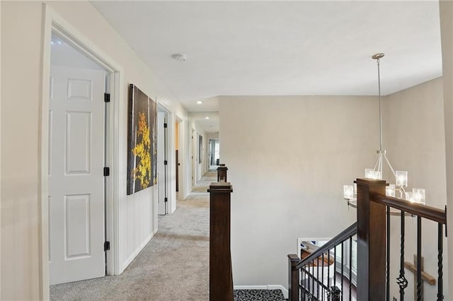corridor featuring an upstairs landing, light carpet, and baseboards