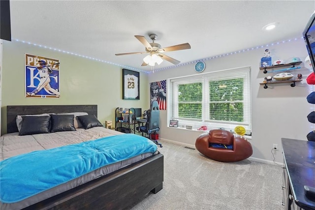 carpeted bedroom featuring baseboards, a ceiling fan, and a textured ceiling