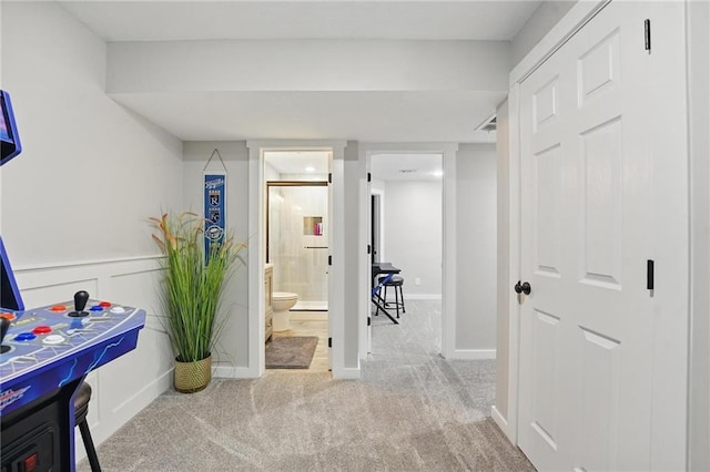hallway featuring carpet flooring and baseboards