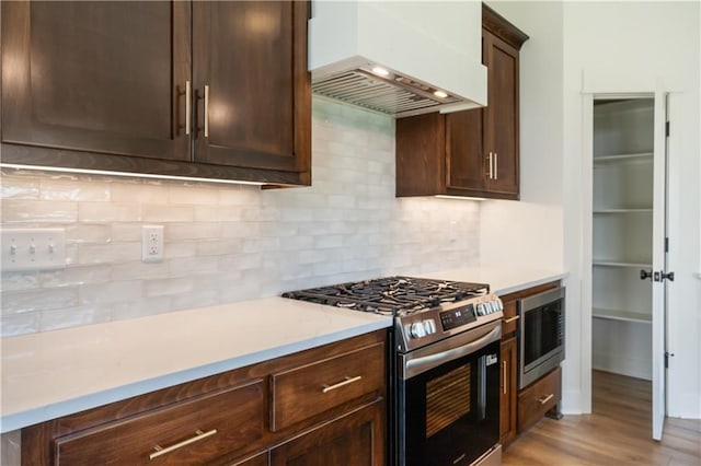 1604 Mulberry St, Pleasant Hill, MO 64080 - kitchen featuring appliances with stainless steel finishes, custom range hood, dark brown cabinetry, and tasteful backsplash