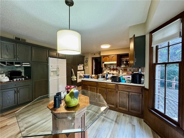 5212 Somerset Dr, Prairie Village, KS 66207 - kitchen featuring white appliances, a textured ceiling, under cabinet range hood, light wood finished floors, and light countertops
