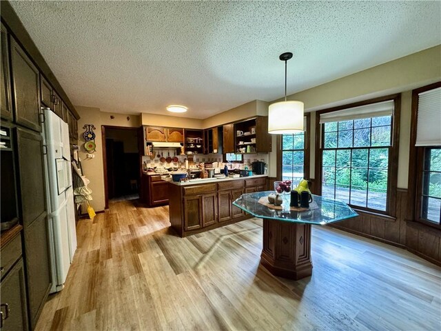 5212 Somerset Dr, Prairie Village, KS 66207 - kitchen with a textured ceiling, a kitchen island, open shelves, healthy amount of natural light, and light wood-style floors