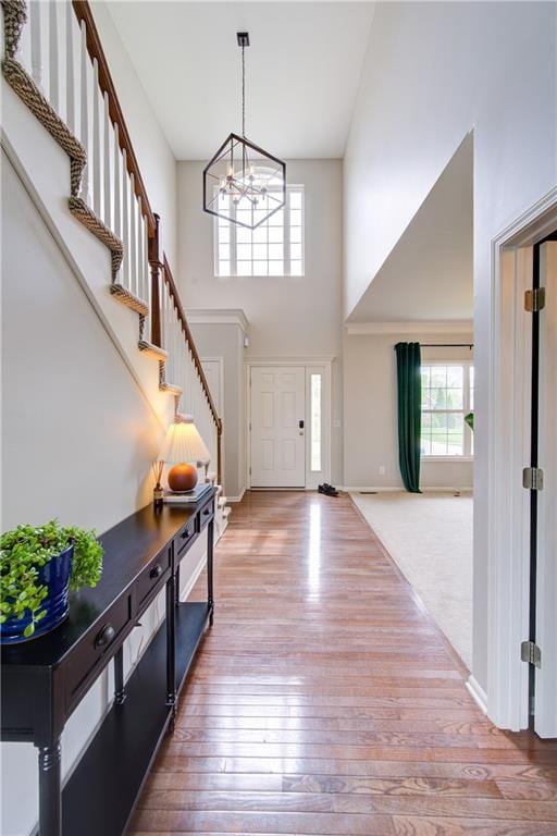 8812 NE 101st St, Kansas City, MO 64157 - foyer featuring a high ceiling, a chandelier, wood-type flooring, stairway, and baseboards